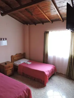 a bedroom with two beds and a window at Hotel La Casona Ituango in Ituango