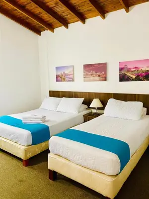 two beds sitting next to each other in a bedroom at Hotel Confort LaCeja in La Ceja