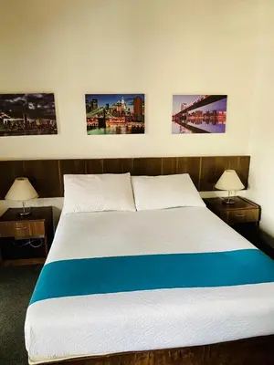 a bed in a room with three pictures on the wall at Hotel Confort LaCeja in La Ceja