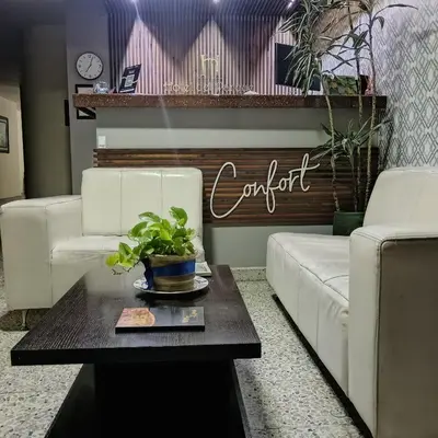 a living room with two white couches and a table at Hotel Confort LaCeja in La Ceja