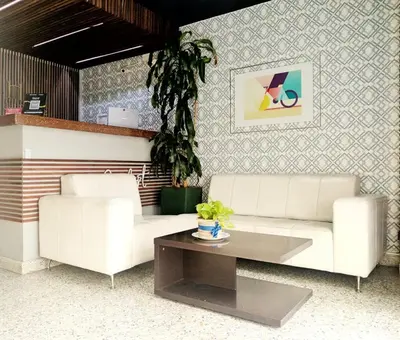 a living room with two white couches and a coffee table at Hotel Confort LaCeja in La Ceja