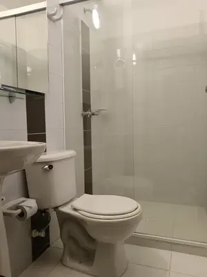 a bathroom with a toilet and a glass shower at Hotel Confort LaCeja in La Ceja