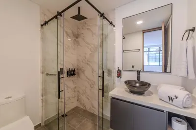 a bathroom with a sink and a glass shower at The Living House by Wynwood House in Medellín
