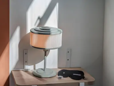 a lamp on a wooden table with a hat on it at The Living House by Wynwood House in Medellín