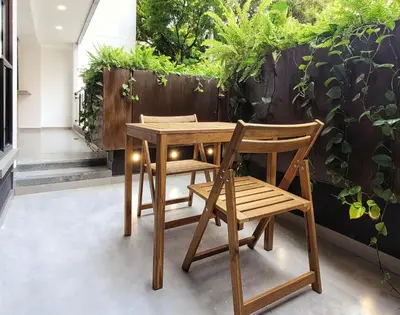 a wooden table and two chairs next to a fence with plants at The Living House by Wynwood House in Medellín
