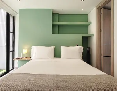 a bedroom with a large bed with white pillows at The Living House by Wynwood House in Medellín