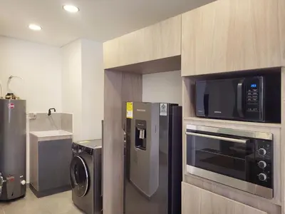 a kitchen with a microwave and a washer and dryer at The Living House by Wynwood House in Medellín