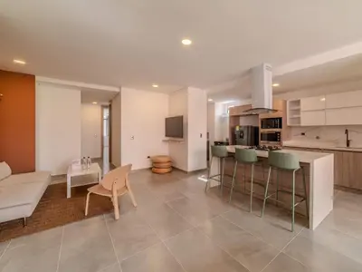 a kitchen and living room with a table and chairs at The Living House by Wynwood House in Medellín