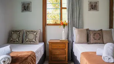 a bedroom with two beds and a window at Las Casas de Tomate in Guatapé