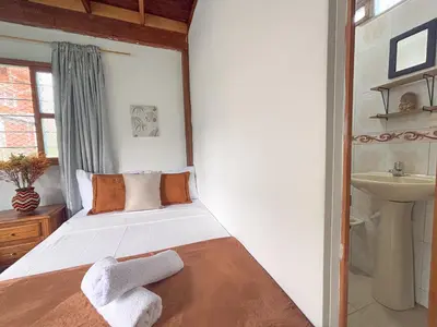a bedroom with a bed with towels on it at Las Casas de Tomate in Guatapé