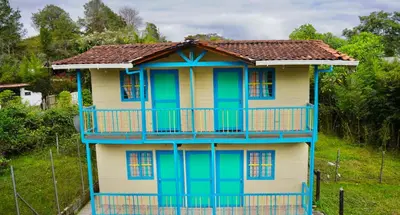 a blue and yellow house with a balcony at Las Casas de Tomate in Guatapé