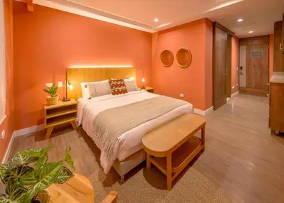a bedroom with a large bed with orange walls at Contemporary Space Steps from El Tesoro 305 in Medellín