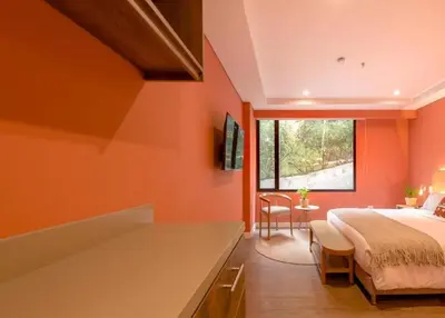 a bedroom with orange walls and a bed and a window at Contemporary Space Steps from El Tesoro 305 in Medellín