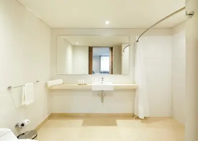 a white bathroom with a sink and a mirror at Contemporary Space Steps from El Tesoro 305 in Medellín