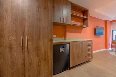 a kitchen with wooden cabinets and a black dishwasher at El Tesoro Escape Modern & Cozy Room 303 in Medellín