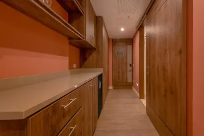 a kitchen with wooden cabinets and a long hallway at Room Modern Elegance Just Steps from El Tesoro 306 in Medellín