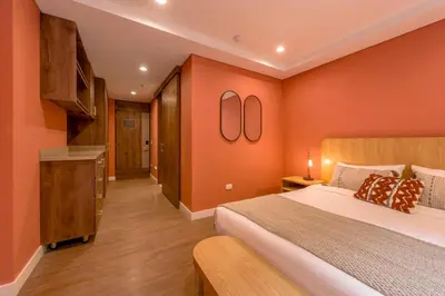 a bedroom with orange walls and a large bed at Room Modern Elegance Just Steps from El Tesoro 306 in Medellín