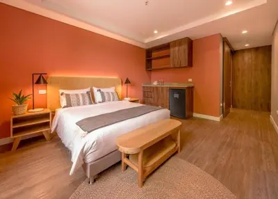 a bedroom with a large bed with orange walls at Comfort and Style -Exclusive Area in El Tesoro 307 in Medellín