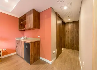 a kitchen with orange walls and wooden cabinets at Comfort and Style -Exclusive Area in El Tesoro 307 in Medellín