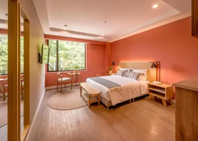a bedroom with red walls and a bed and a table at Comfort and Style -Exclusive Area in El Tesoro 307 in Medellín