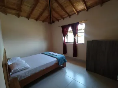 a bedroom with a bed and a window at Centro vacacional campo verde in Cocorná