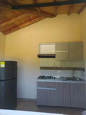 a kitchen with a stove and a refrigerator at Centro vacacional campo verde in Cocorná