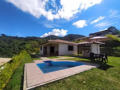 a backyard with a pool and a house at Centro vacacional campo verde in Cocorná