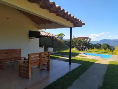 a patio with benches and a view of a pool at Centro vacacional campo verde in Cocorná