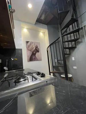 a kitchen with a stove and a spiral staircase at Apartamento pequeño la 70 estadio laurles in Medellín