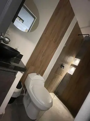 a bathroom with a toilet and a wooden door at Apartamento pequeño la 70 estadio laurles in Medellín