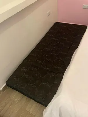 a bed in a room with a black comforter at Apartamento pequeño la 70 estadio laurles in Medellín