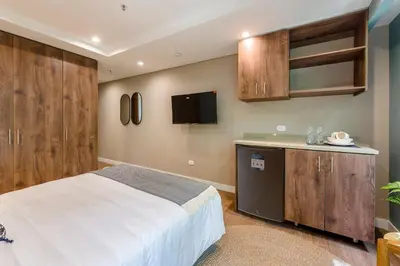 a bedroom with a bed and a kitchen with cabinets at Vibrant Space- Explore Wonders in El Tesoro 313 in Medellín