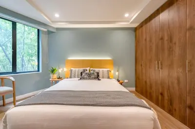a bedroom with a large bed and wooden cabinets at Vibrant Space- Explore Wonders in El Tesoro 313 in Medellín