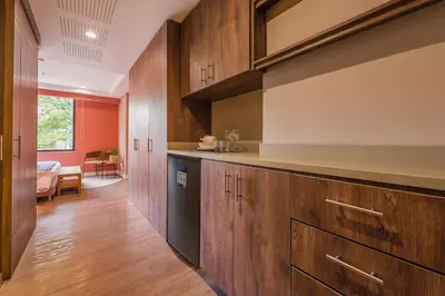 a kitchen with wooden cabinets and a black dishwasher at Elegant Space in El Tesoro Recharge in Comfort 308 in Medellín
