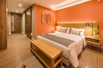 a bedroom with a large bed and orange walls at Elegant Space in El Tesoro Recharge in Comfort 308 in Medellín
