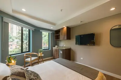 a bedroom with a large bed and a tv at El Tesoro Stylish Escape - Urban Vibes 312 in Medellín