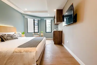 a bedroom with a large bed and a flat screen tv at El Tesoro Stylish Escape - Urban Vibes 312 in Medellín