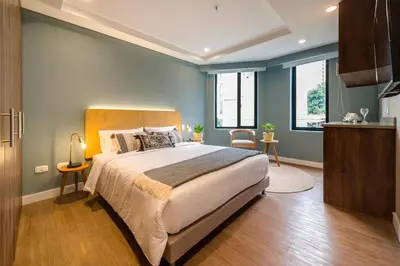 a bedroom with a large bed with blue walls at El Tesoro Stylish Escape - Urban Vibes 312 in Medellín