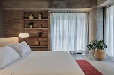 a bedroom with a large white bed and a window at The Somos Loho Hotel in Medellín