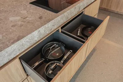 a wooden drawer with a cupboard filled with kitchen utensils at The Somos Loho Hotel in Medellín