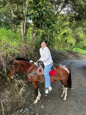 a woman riding a horse on a dirt road at Coffee Tour, Colombia Aranzazu Caldas- Andean Motmot coffee in Aranzazu