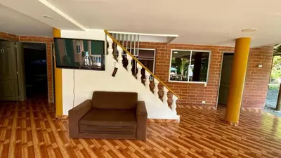 a living room with a chair and a staircase at Espectacular finca , San Jerónimo in San Jerónimo