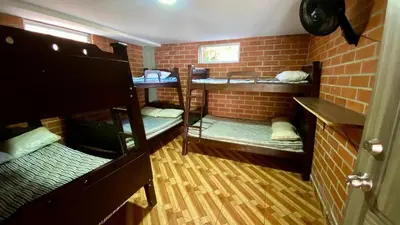 a room with three bunk beds and a brick wall at Espectacular finca , San Jerónimo in San Jerónimo
