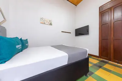a bedroom with a bed and a tv on the wall at Ayenda Sarayu House in Medellín