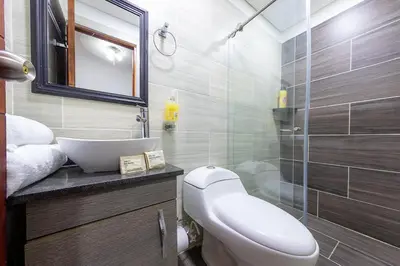 a bathroom with a toilet and a sink and a shower at Ayenda Sarayu House in Medellín