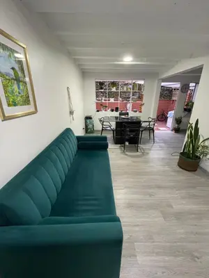 a living room with a green couch and a table at Hermosa Casa vía al nevado, termales del otoño, cerca al bosque complejo deportivo y clínica, sector san Marcel in Manizales