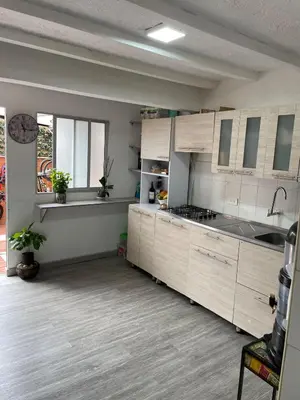 a kitchen with white cabinets and a counter top at Hermosa Casa vía al nevado, termales del otoño, cerca al bosque complejo deportivo y clínica, sector san Marcel in Manizales