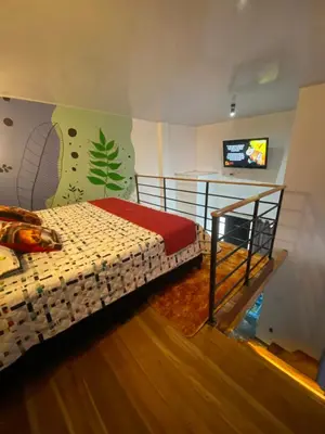 a bedroom with a bed and a flat screen tv at Habitación tipo loft turistico in Mariquita
