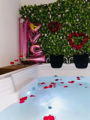 a bath tub filled with red flowers and plants at Habitación tipo loft turistico in Mariquita