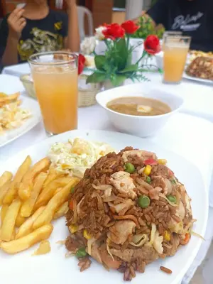 a plate of food on a table with french fries at hosteria y camping piedras verdes in Sopetran